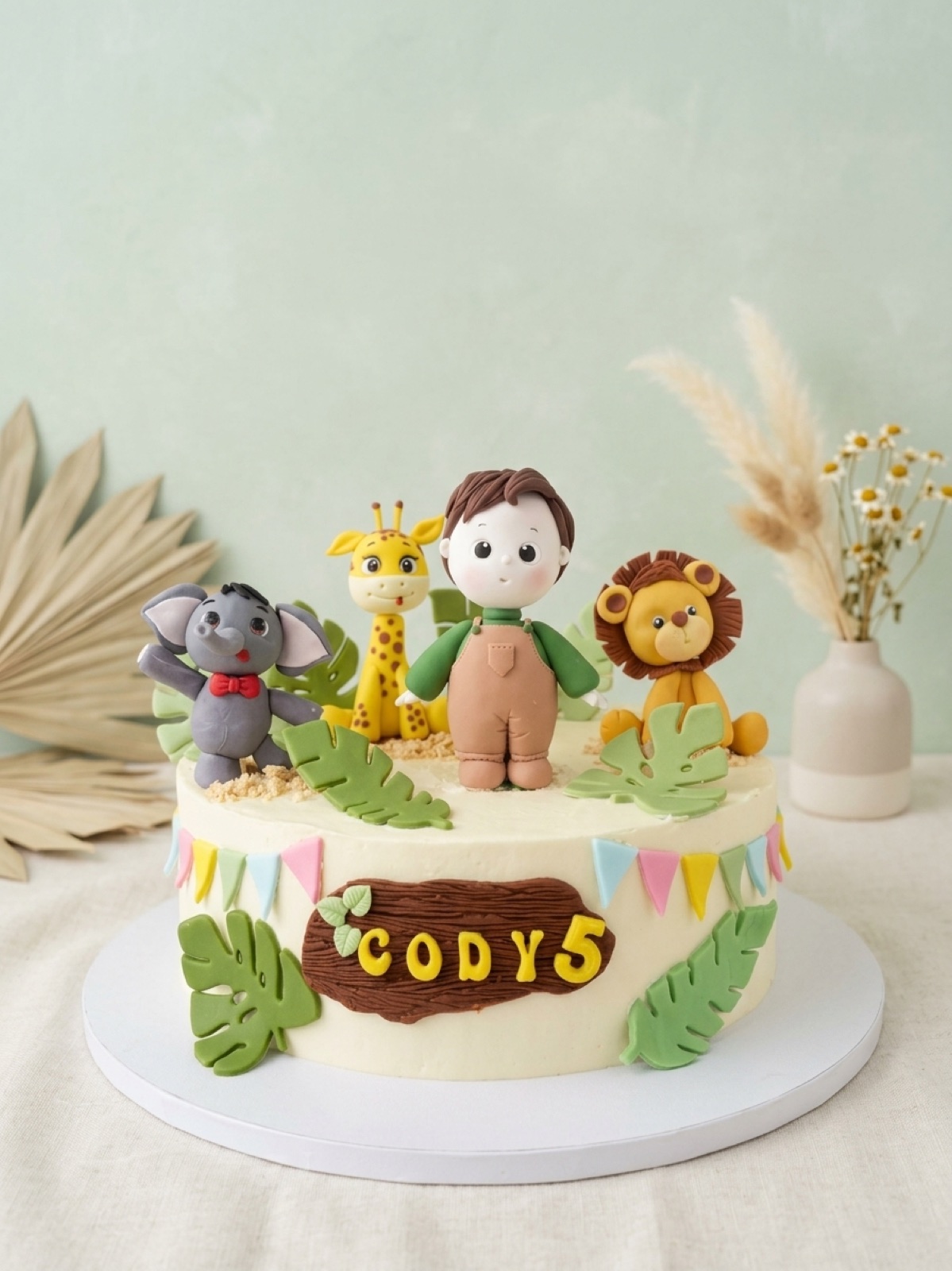 Safari birthday cake with a handmade boy, elephant, giraffe and lion